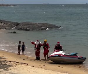 Papai Noel desembarca do Jet-ski e acena para o público 